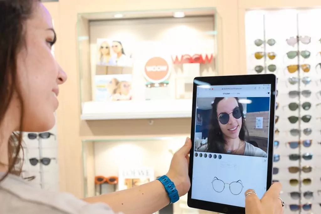 Une cliente essayant des lunettes à l'aide d'une tablette